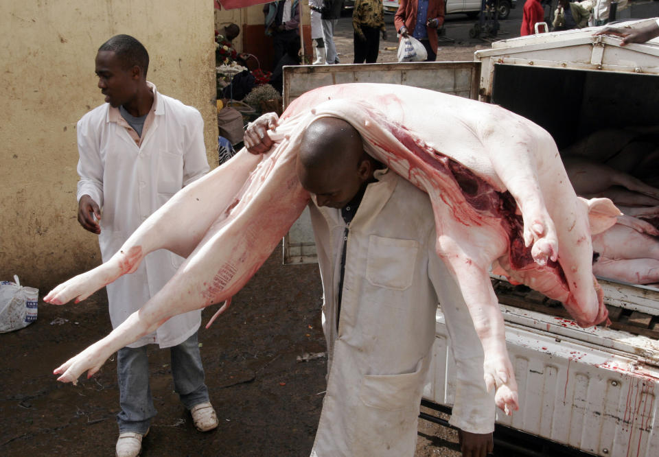 FILE - A loader carries a full gutted Pig at a City Market in Nairobi, Kenya, on Dec. 29, 2009. The ballooning debt in East Africa's economic hub of Kenya is expected to grow even more after deadly protests forced the rejection of a finance bill that President William Ruto said was needed to raise revenue. (AP Photo/Sayyid Azim, File)