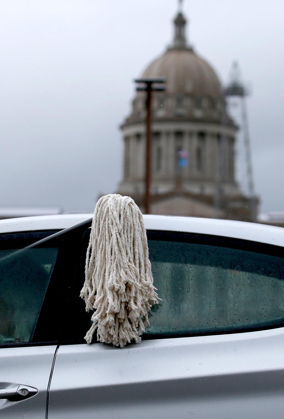 A mop serves as a symbol to clean up corruption in Oklahoma politics during a rally Wednesday staged by Clean-Up Oklahoma at the state Capitol.