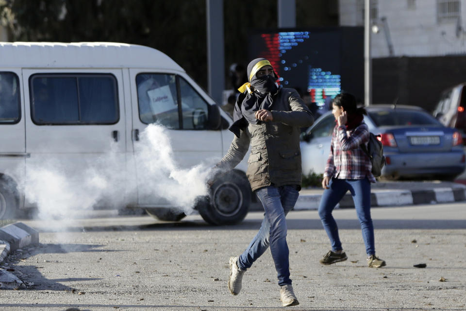 Palestinian protestor throws back a teargas canister during clashes with Israeli troo[s near Ramallah, West Bank, Thursday, Dec. 13, 2018. (AP Photo/Mahmoud Illean)