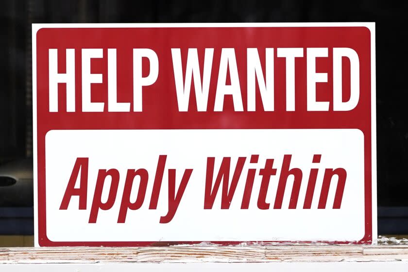 A "help wanted" sign posted in a window.