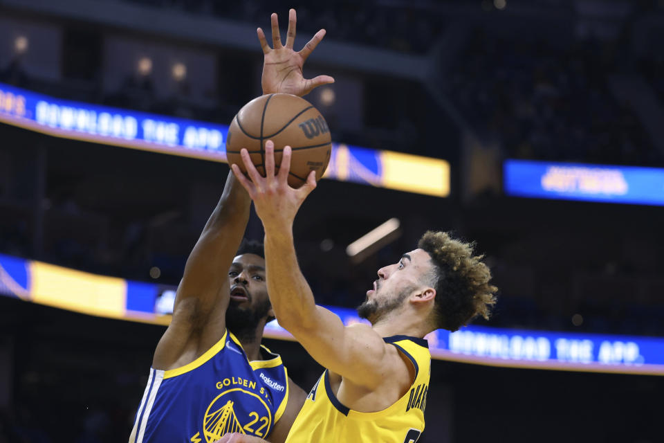 Indiana Pacers guard Chris Duarte right, shoots against Golden State Warriors forward Andrew Wiggins (22) during the first half of an NBA basketball game in San Francisco, Thursday, Jan. 20, 2022. (AP Photo/Jed Jacobsohn)