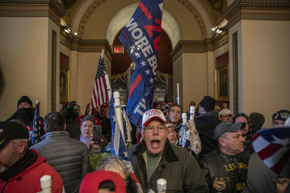 Demonstrators walk through the US Capitol after breaching barricades to the building during a protest outside.