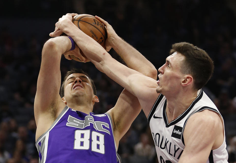 Brooklyn Nets forward Rodions Kurucs, right, forces a jump ball with Sacramento Kings forward Nemanja Bjelica during the first quarter of an NBA basketball game Tuesday, March 19, 2019, in Sacramento, Calif. (AP Photo/Rich Pedroncelli)