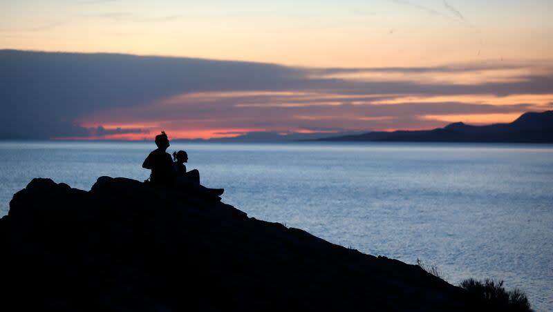 Two people watch the sunset over the Great Salt Lake from Ladyfinger Point on Antelope Island on Monday, June 5, 2023. Utah might be an enticing option for couples seeking a memorable setting for an engagement.