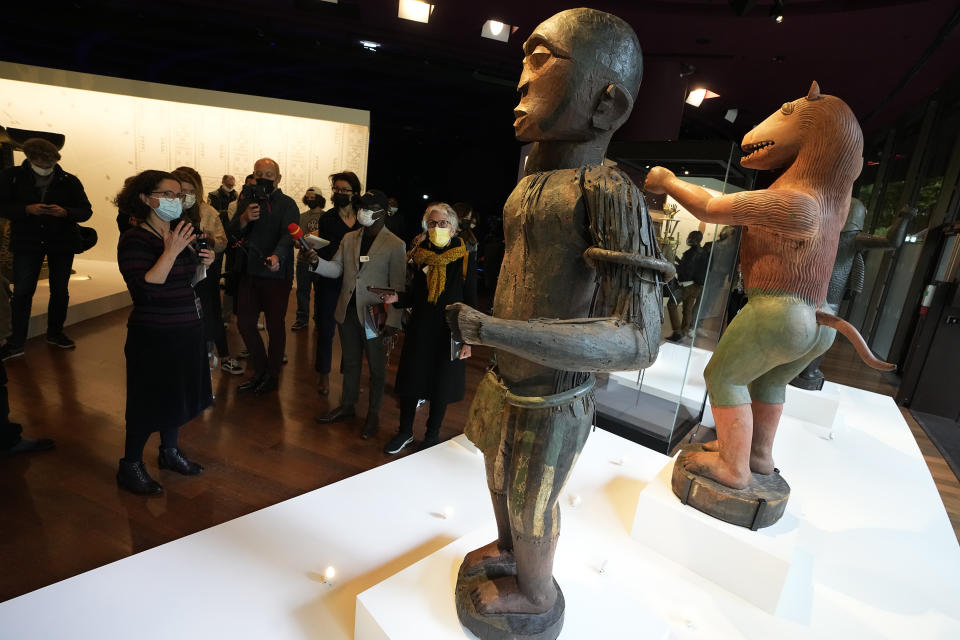 The royal statues of a half-man half-bird, left, of King Ghezo, and half-man half-lion of Benin's 19th century King Glele, are pictured at the Quai Branly–Jacques Chirac museum, Monday, Oct. 25, 2021 in Paris. In a decision with potential ramifications across European museums, France is displaying 26 looted colonial-era artifacts for one last time before returning them home to Benin. The wooden anthropomorphic statues, royal thrones and sacred altars were pilfered by the French army in the 19th century from Western Africa. (AP Photo/Michel Euler)