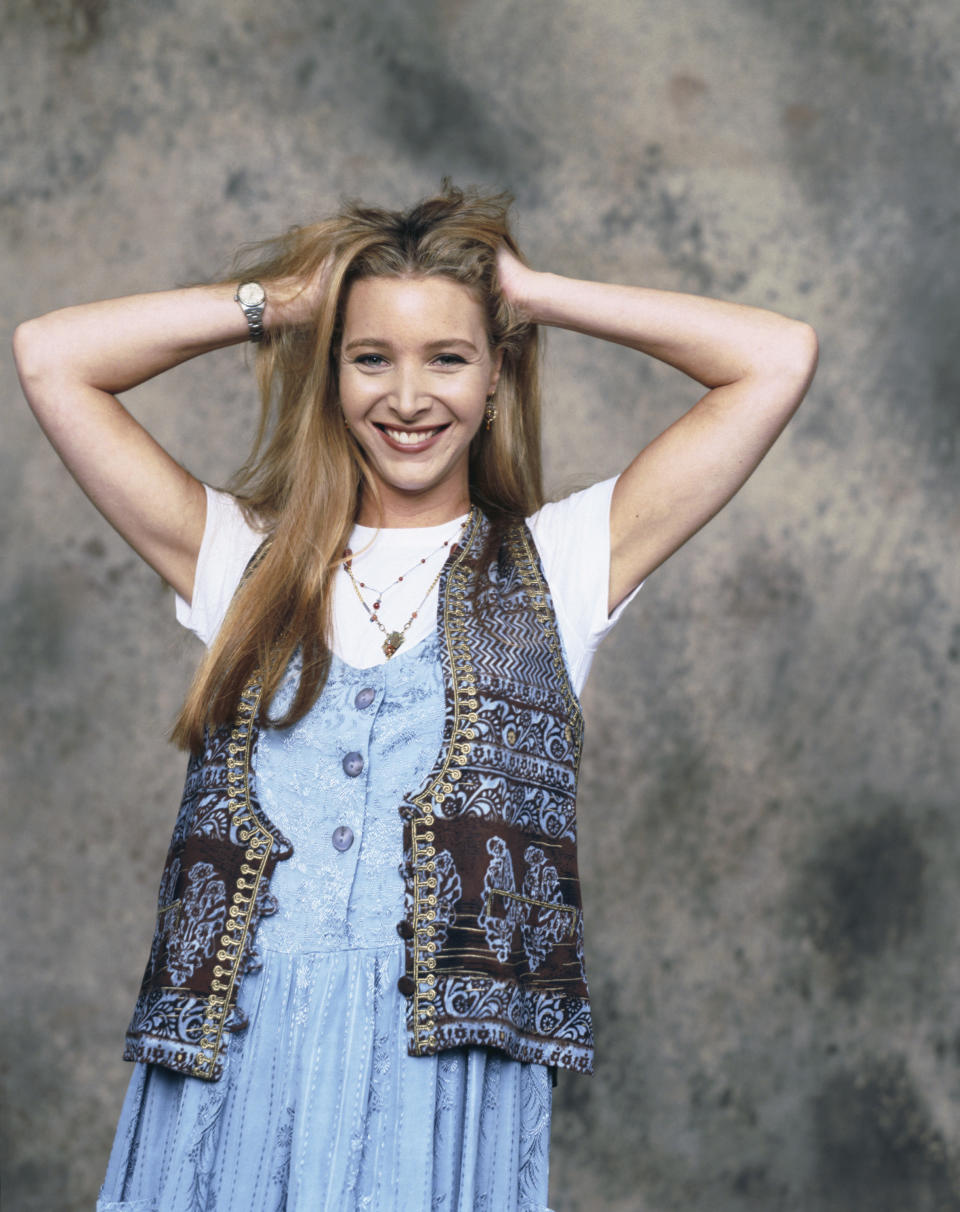 Lisa Kudrow in 1994 smiling with her hands in her hair