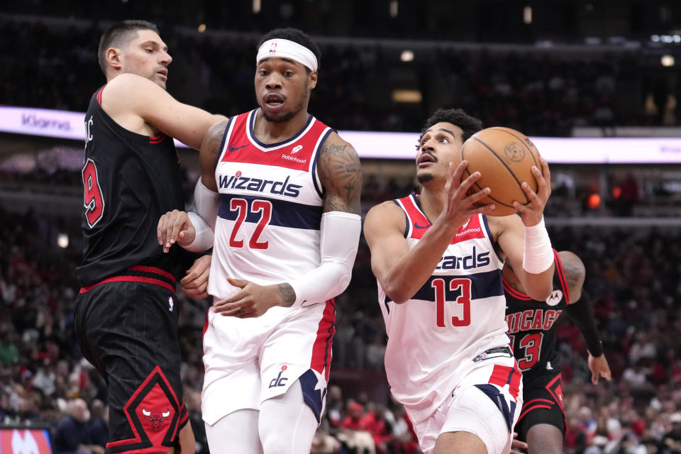 Washington Wizards' Jordan Poole drives to the basket off a pick set on Chicago Bulls' Nikola Vucevic (9) by Richaun Holmes during the first half of an NBA basketball game Monday, March 25, 2024, in Chicago. (AP Photo/Charles Rex Arbogast)