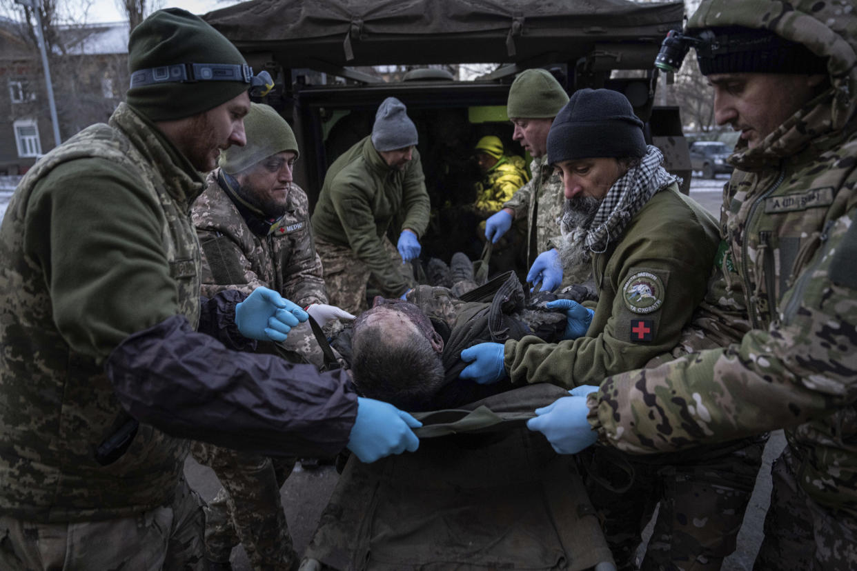 Ukrainian military medics carry an injured Ukrainian serviceman evacuated from the battlefield into a hospital in Donetsk region, Ukraine, Monday, Jan. 9, 2023. A serviceman did not survive. (AP Photo/Evgeniy Maloletka)