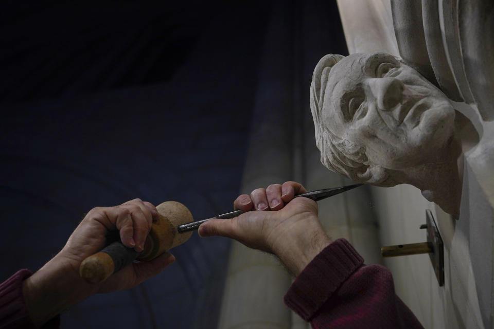 Stone carver Sean Callahan uses a chisel and mallet as he works on a limestone head of Holocaust survivor and Nobel Peace Prize winning author Elie Wiesel in the Human Rights Porch at the Washington National Cathedral, Thursday, April 1, 2021. (AP Photo/Carolyn Kaster)