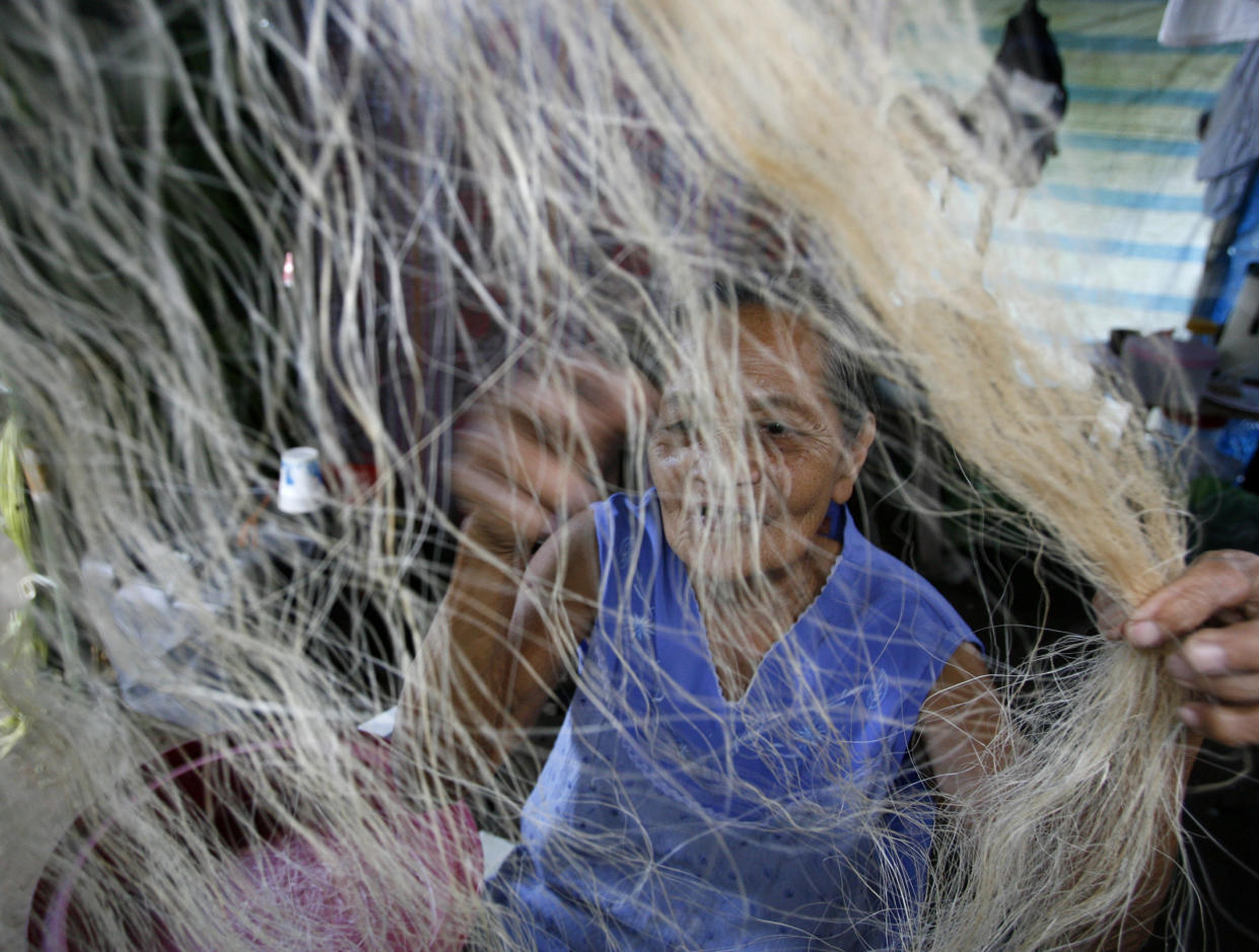 An evacuee sorts out an abaca weave, a major handicraft in the area, at a temporary shelter for villagers living on the slopes of Mayon volcano in San Jose, Albay, about 500 km (310 miles) south of Manila December 19, 2009. Philippine troops evacuated about 12,000 people from villages at the base of the country's most active volcano as it showed signs of a major eruption, officials said on Friday.   REUTERS/Erik de Castro (PHILIPPINES)