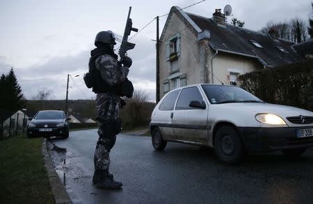 A member of the French GIPN intervention police forces secures a neighbourhood in Corcy, northeast of Paris January 8, 2015. REUTERS/Christian Hartmann