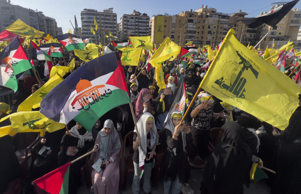 Supporters of the Iranian-backed Hezbollah group wave Palestinian and their group flags, as they wait the speech of Hezbollah leader Sayyed Hassan Nasrallah, during a rally to commemorate Hezbollah fighters who were killed in South Lebanon last few weeks while fighting against the Israeli forces, in Beirut, Lebanon, Friday, Nov. 3, 2023. Nasrallah's speech had been widely anticipated throughout the region as a sign of whether the Israel-Hamas conflict would spiral into a regional war. (AP Photo/Hussein Malla)