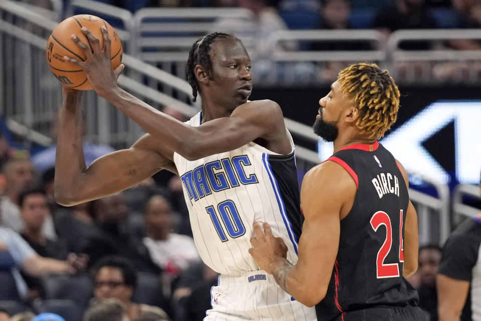 Orlando Magic's Bol Bol (10) looks to pass the ball as Toronto Raptors' Khem Birch (24) defends during the first half of an NBA basketball game Friday, Dec. 9, 2022, in Orlando, Fla. (AP Photo/John Raoux)