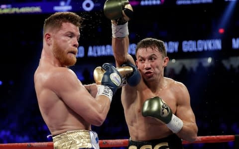 Gennady Golovkin, right, throws a right at Canelo Alvarez - Credit: AP