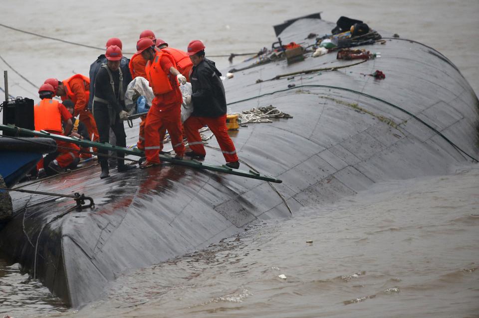 Rescue workers carry a body from a sunken ship in the Jianli section of Yangtze River, Hubei province