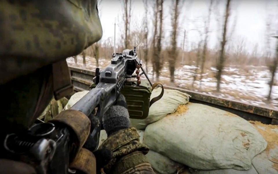  A Russian soldier on a military truck mans a machine gun as it drives through an undisclosed location in Ukraine - Russian Defence Ministry Press Service 