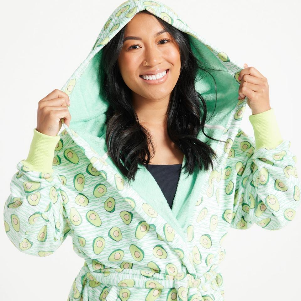 Woman with long dark hair wears the green Oodie Avocado Bathrobe, $74