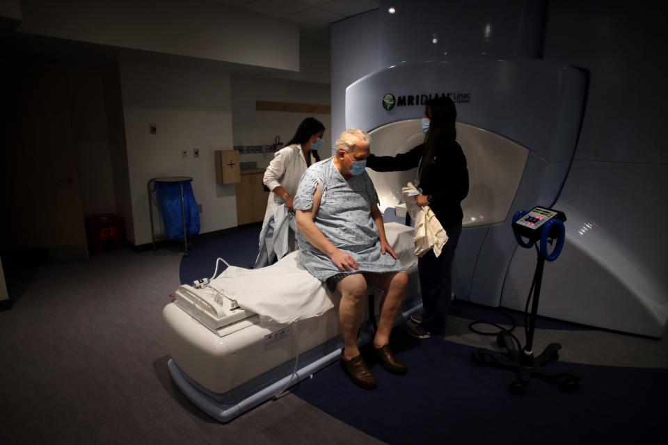 BOSTON, MA - JUNE 10: Radiation therapists Jessica Penney, left, and Jennifer Campbell, right, prepare cancer patient Kenton Fabrick for his treatment in the Radiation Oncology Department at Brigham and Women's Hospital in Boston, MA on on June 10, 2020. (Photo by Craig F. Walker/The Boston Globe via Getty Images)