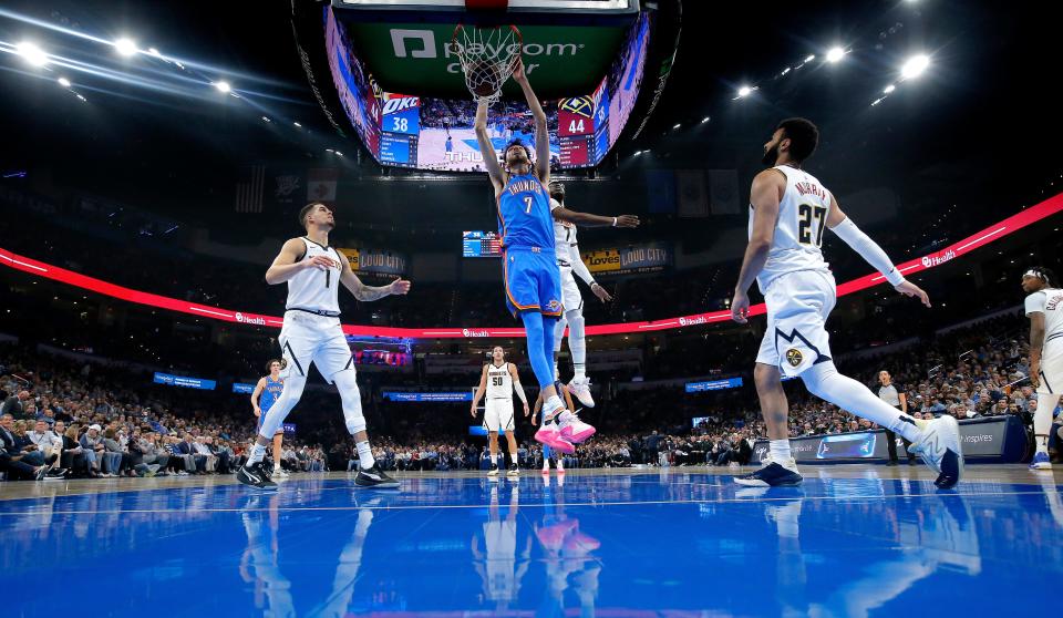 Oklahoma City Thunder forward Chet Holmgren (7) dunks the ball in between Denver Nuggets forward Michael Porter Jr. (1) and Jamal Murray (27) in the first half of the NBA basketball game between the Oklahoma City Thunder and the Denver Nuggets at Paycom Center in Oklahoma City, Wednesday, Jan. 31, 2024.