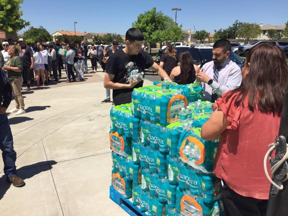 Bottled water is handed out as parents wait to pick up their children at Cesar Chavez Junior High after lockdown Monday. Ken Carlson/kcarlson@modbee.com