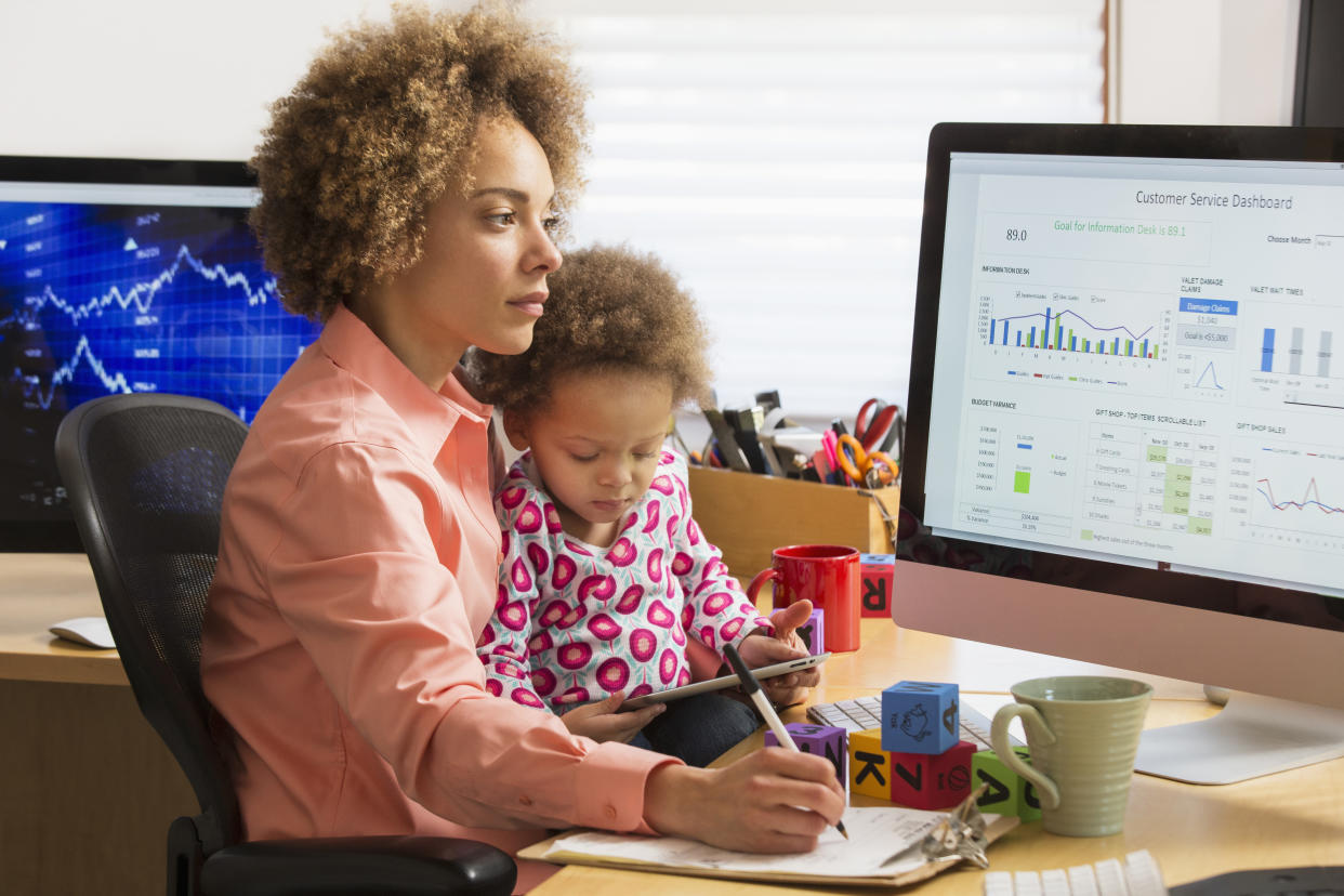 Black businesswoman with daughter working at home