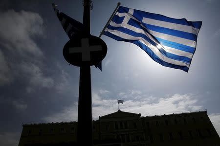 A Greek national flag flutters as the parliament building is seen in the background in Athens March 24, 2015. REUTERS/Alkis Konstantinidis
