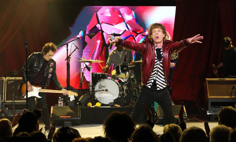 mick jagger singing with the rolling stones on a stage