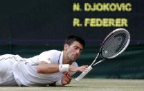 Novak Djokovic of Serbia slips during his men's singles final tennis match against Roger Federer of Switzerland at the Wimbledon Tennis Championships, in London July 6, 2014. REUTERS/Stefan Wermuth