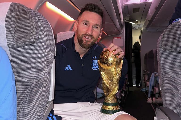 Lionel Messi en el avión de regreso a Argentina con la Copa del Mundo en sus manos