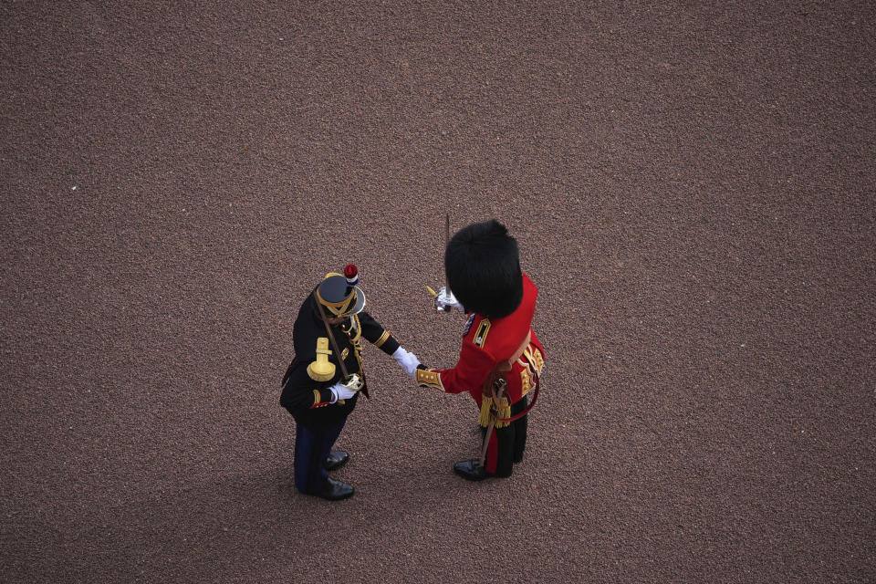 A member of the Scots Guards and a member of France's 1er Regiment de le Garde Republicaine shake hands as they partake in the Changing of the Guard ceremony at Buckingham Palace, to commemorate the 120th anniversary of the Entente Cordiale - the historic diplomatic agreement between Britain and France which laid the groundwork for their collaboration in both world wars, in London, Monday, April 8, 2024. France is the first non-Commonwealth country to take part in the Changing of the Guard. (Aaron Chown/PA via AP)