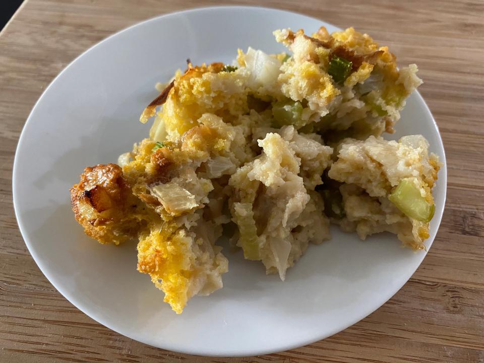 Paula Deen's stuffing served on white plate on wooden cutting board