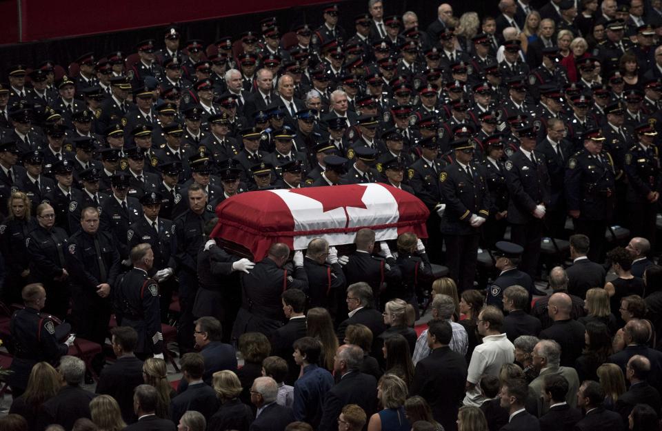 <p>The flag-draped casket of slain Fredericton police officer Cst. Robb Costello is carried past members of the Fredericton Police department, family, and friends during a regimental funeral for Cst. Costello and Cst. Sara Burns on in Fredericton on Saturday, Aug. 18, 2018. (Photo from The Canadian Press/Darren Calabrese) </p>
