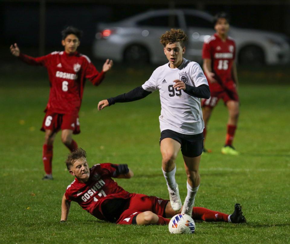 Penn’s Andre Gomez (99) advances the ball past Goshen’s Hayden Clark (17) during Wednesday night’s regional game at Goshen.