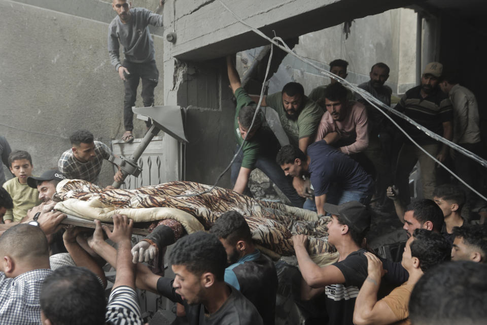 Palestinians carry a body of a dead person that was found under the rubble of a destroyed house following an Israeli airstrike in Khan Younis refugee camp, southern Gaza Strip, Saturday, Nov. 18, 2023. (AP Photo/Mohammed Dahman)