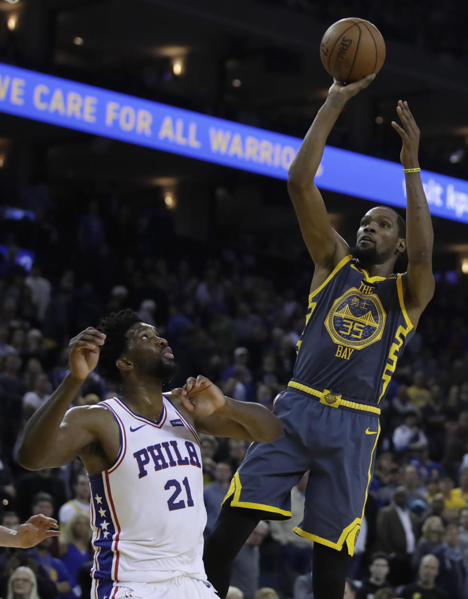 Golden State Warriors' Kevin Durant shoots over Philadelphia 76ers' Joel Embiid (21) during the second half of an NBA basketball game Thursday, Jan. 31, 2019, in Oakland, Calif. (AP Photo/Ben Margot)