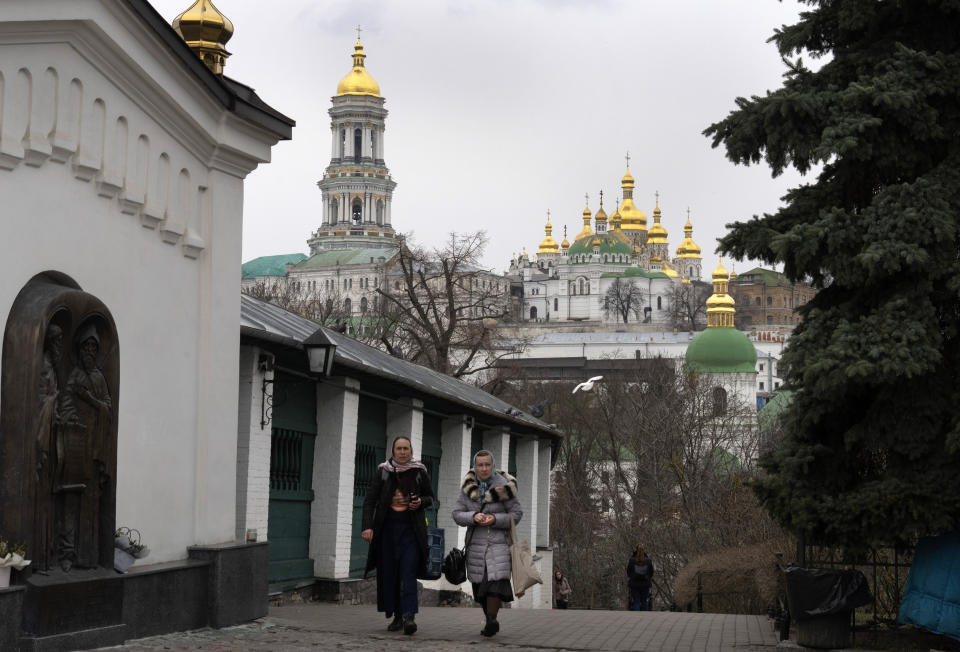 People walk in the Monastery of the Caves, also known as Kyiv-Pechersk Lavra, one of the holiest sites of Eastern Orthodox Christians, in Kyiv, Ukraine, Thursday, March 23, 2023. Tensions are on the rise at a prominent Orthodox monastery in Kyiv where the monks are facing eviction later this month. The Ukrainian government accuses the monks of links to Moscow, even though they claim to have severed ties with the Russian Orthodox Church following Russia's full-scale of invasion of Ukraine. (AP Photo/Efrem Lukatsky)