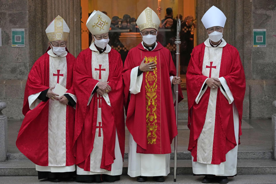 Stephen Chow, second right, wearing surgical mask to protect against the coronavirus, poses after the episcopal ordination ceremony as the new Bishop of the Catholic Diocese, in Hong Kong, Saturday, Dec. 4, 2021. The new head of Hong Kong's Catholic diocese expressed hope Saturday that he could foster healing in a congregation and a city divided by the continuing fallout from massive anti-government protests in 2019. (AP Photo/Kin Cheung)