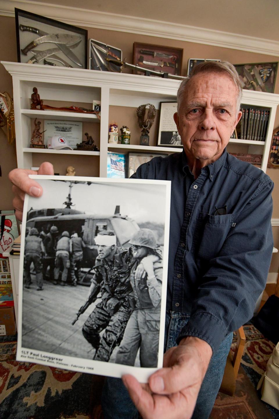 Vietnam veteran Col. Paul Longgrear is seen at his home in Pine Mountain, Ga. on Monday January 23, 2023. Longgrear is one of the few American survivors of the battle of Lang Vei. He is seen in a dramatic photo from the war that he holds.
