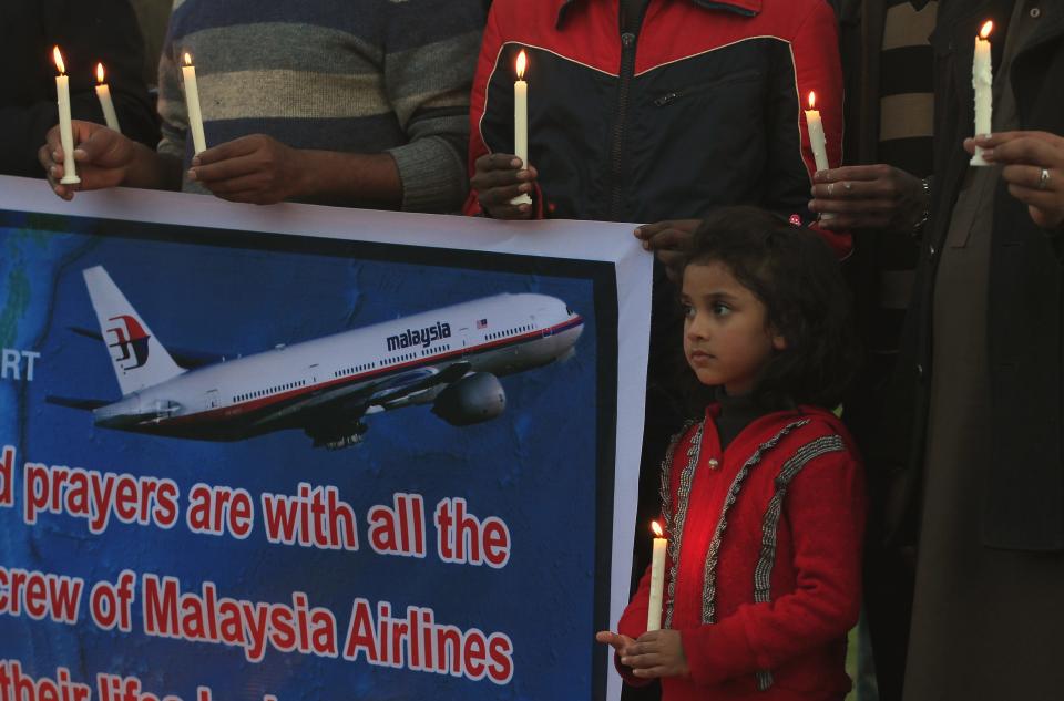 Pakistani Christian girl holds a candle to pray for the passengers and crew members of the missing Malaysia Airline flight MH370 in Islamabad