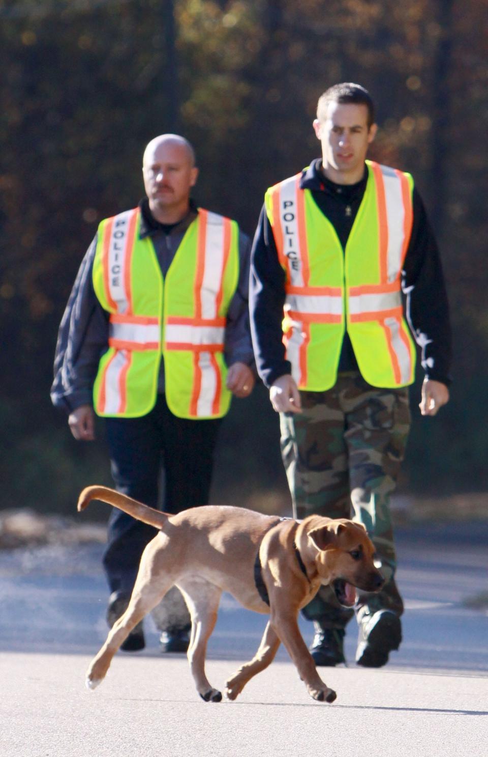 Law enforcement officers with a working dog search for the body of Shaniya Davis south of Sanford on Nov. 16, 2009.