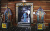 An employee sanitises a Hindu temple in Mumbai, India, Sunday, Nov. 15, 2020. India is second in the world in total reported coronavirus cases behind the U.S., but daily infections have been on the decline since the middle of September. (AP Photo/Rafiq Maqbool)
