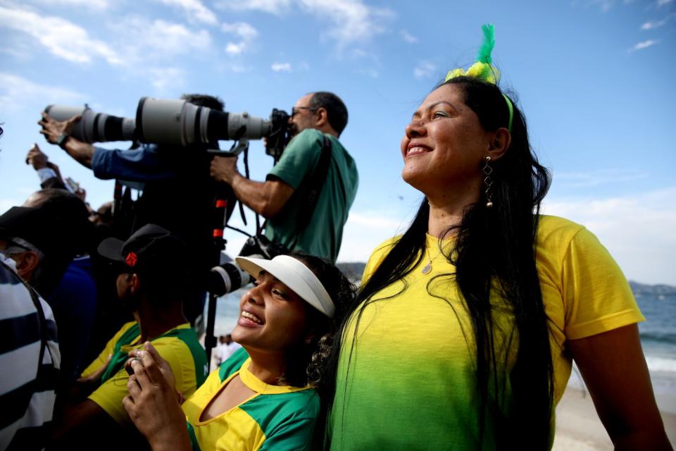 Supporters of Brazilian President Jair Bolsonaro, 67, try to get a look at the president