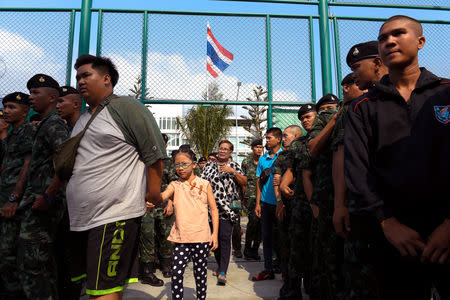 Civilians walk by as soldiers line up to vote in the general election at a polling station in Bangkok, Thailand March 24, 2019. REUTERS/Cory Wright