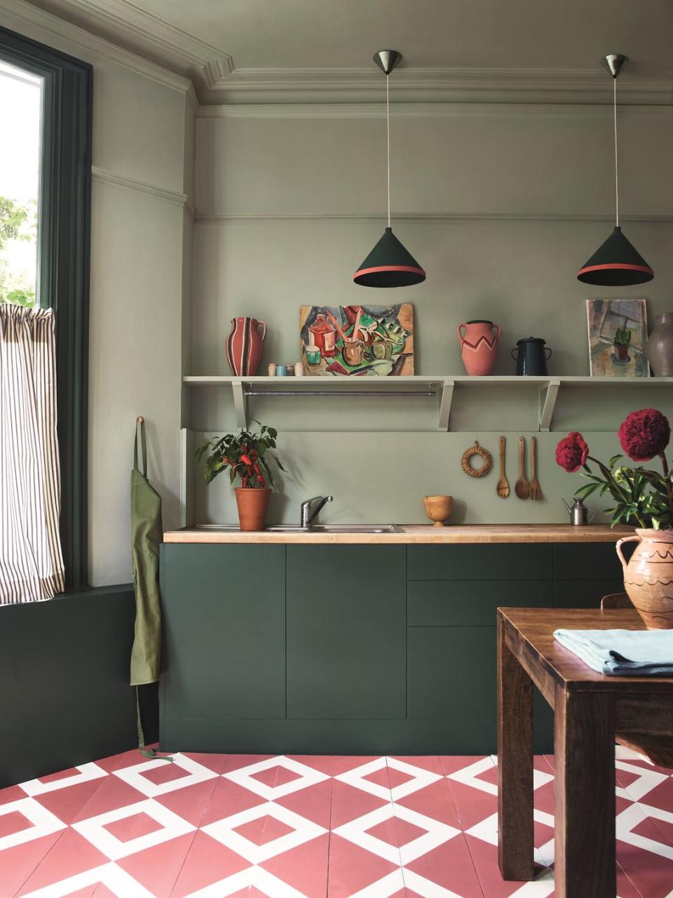 a kitchen with a countertop and a table with a vase of flowers