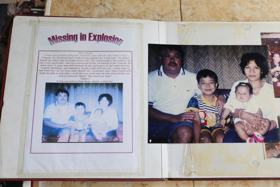 Photos of Gede Badrawan and his family are seen as Ni Luh Erniati and her son go through family albums in Bali, Indonesia on Thursday, April 25, 2019. Gede, Erniati's late husband, was one of 202 people killed in the 2002 bombings in Bali's nightclub district. (AP Photo/Firdia Lisnawati)