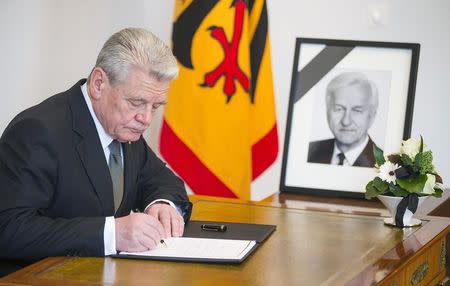 German President Joachim Gauck writes in a condolence book for late former president Richard von Weizsaecker, in Berlin January 31, 2015. REUTERS/Hannibal Hanschke