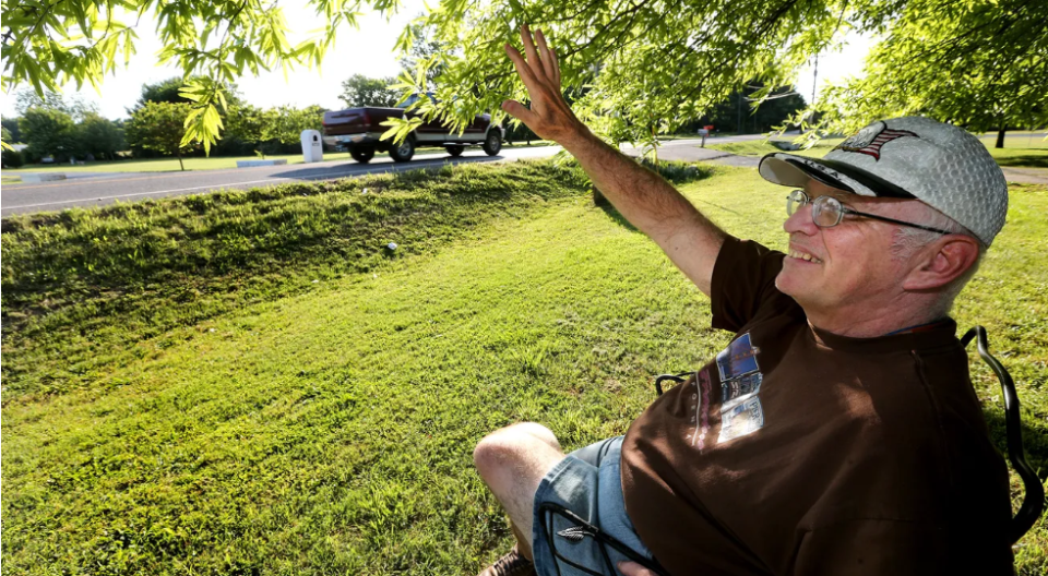 Paul Tidwell sits on his front lawn and waves at passers by along Old Nashville Highway on May 19, 2016, and some commuters respond by honking horns and shouting back, "Hey, Paul!"