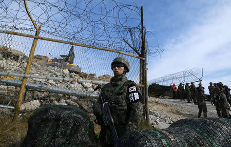 South Korean soldiers stand guard as construction equipment destroy a guard post in the Demilitarized Zone dividing the two Koreas in Cheorwon on November 15, 2018. Jung Yeon-je/Pool via Reuters