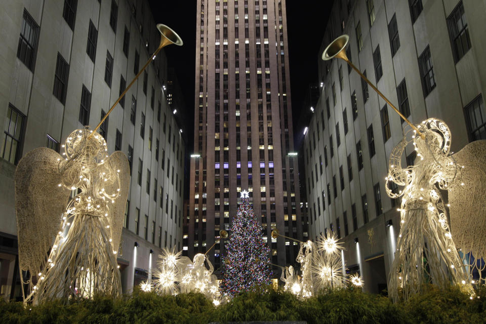 Angels decorations frame the Rockefeller Center Christmas tree after it was lit during the 80th annual tree lighting ceremony at Rockefeller Center in New York, Wednesday, Nov. 28, 2012.  (AP Photo/Kathy Willens)