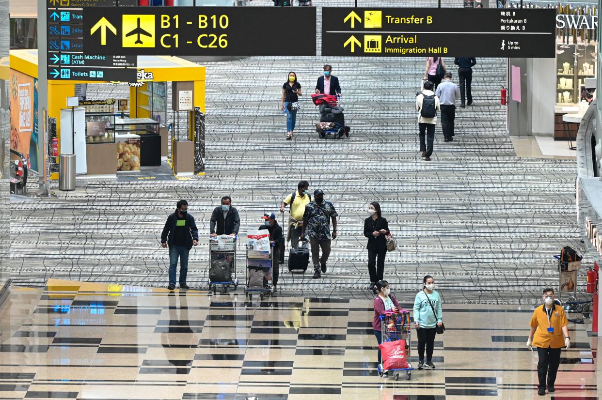 Travellers walk through the transit hall of Changi International Airport in Singapore on January 12, 2022. (PHOTO: AFP via Getty Images)